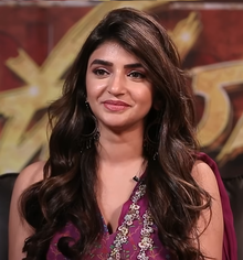 close-up of Sreeleela wearing a patterned, low-cut, sleeveless top, smiling and looking right of camera