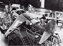 Three-quarter black and white view of a jet aircraft undergoing construction