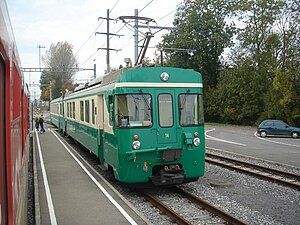 Green and white train at a station