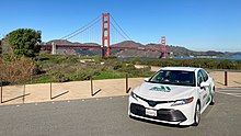 An aiMotive prototype Toyota Camry in front of the Golden Gate bridge.