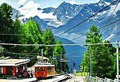 A wider view of the station, with the track of the Riffelalp tram visible beside the station building