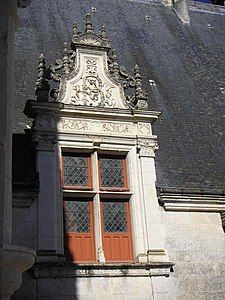 Window with a lucarne, raised above the roof and framed with sculpted pilasters, characteristic of French Renaissance style