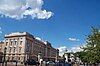 Grand city building below beautiful blue sky and clouds