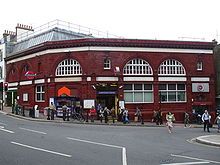 Terracotta railway station building at the bottom of a hill