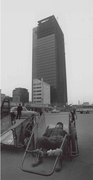 Worker resting in front of a row of highrises under construction in Gwanggyo-dong, Seoul (December 14, 1969)