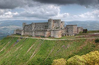 A stone fortress with massive towers on a hill