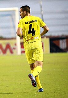 Photograph of the footballer from behind, looking left