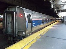 A row of stainless steel cars at a station