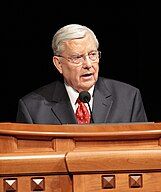 Photo of M. Russell Ballard standing behind a podium and speaking.