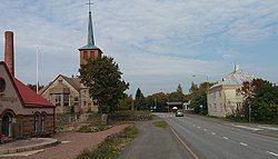 The main street (route 2172) of Panelia; on the left the Panelia Church and the Panelia Dairy.