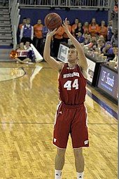 Dark-haired man shooting a basketball