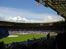 A full football stadium on a clear, bright day