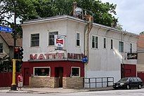 A two-story building on a street corner with a sign on either side of the front corner reading "Matt's"