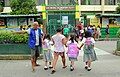 A tanod helping students cross the road at an elementary school in San Miguel II, Dasmariñas, Cavite