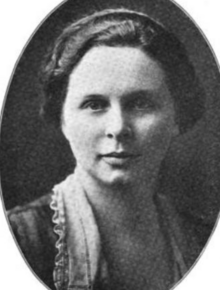 A white woman with wavy hair brushed back from her face, in an oval frame