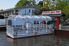 White hand-cranked ferry docked at the shore