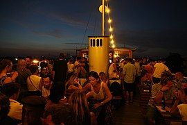 Party guests on the upper deck having a view over nightly Sendling