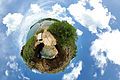 A 360-degree spherical panorama of a beach which uses stereographic projection to create a globe. This is called the little planet effect, in which the area close to the point opposite to the center of projection becomes significantly enlarged.