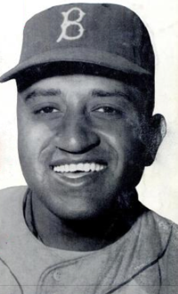 A man in a light baseball uniform and dark cap