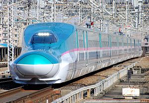 Teal and white bullet train with pink stripe