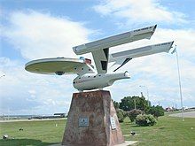 A roadside replica starship atop a stone base