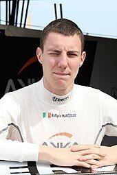 Raffaele Marciello sporting short hair and wearing a white fireproof vest bearing his name, country and two sponsors logos