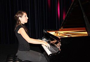 A woman playing a grand piano.