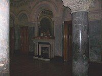 Picture of Dobroyd Castle's Saloon showing the marble pillars, clock, arched mirror and fireplace.