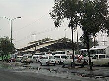 Picture of multiple rooftops, with buildings covered by several buses.