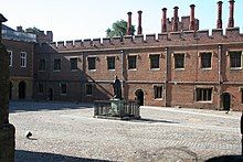 A building in the Tudor style with a courtyard in front