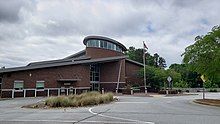 exterior of a suburban library building, photo taken from the parking lot