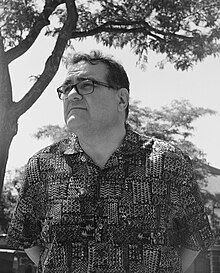 black and white picture of a man wearing a short-sleeved shirt and glasses