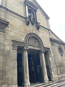 Facade of the old church, with sculpture above of Christ and the Virgin Mary