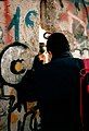 An East German guard (with cap) talks to a Westerner through a broken seam in the Wall in late November 1989.