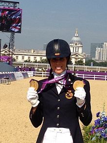 Image of George smiling while holding two gold medals