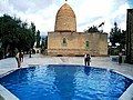 A swimming pool in the foreground of the mausoleum.