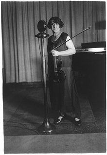 Renée Chemet standing at a microphone, from the George Grantham Bain Collection, Library of Congress.