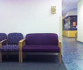 An extra wide chair beside a number of normal sized chairs.