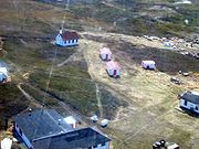 20 June 1999. Bathurst Inlet, Nunavut from the air. At the top of the picture is the old Roman Catholic Mission and also visible are some of the old Hudson's Bay Company buildings in their traditional red and white.