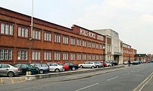 Image of a red brick building with a central front door, the words Rolls-Royce Limited appear above the door in white letters