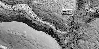 Close view of fractured ground, as seen by HiRISE under HiWish program. Box shows size of football field. The boulders are the size of houses.