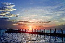 The sun sets over a pier