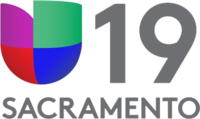 At left, the Univision network logo, consisting of red, purple, green and blue blocks in the shape of a U. At right, a gray number 19 in a sans serif. Beneath is the word "Sacramento".