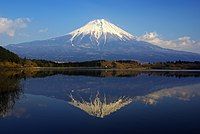 A mountain next to a lake.