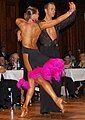 Image 45Latin dancers in their costumes. The woman is wearing backless dress with deep slits on its lower portion, while the man is wearing a shirt with top buttons open. (from Fashion)