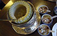 A winter melon soup served from a bowl carved from a melon