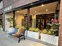 Exterior of restaurant with a rainbow colored bench in front