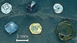 Six non-faceted diamond crystals of 2–3 mm (0.079–0.118 in) size; they are yellow, green-yellow, green-blue, light-blue, light-blue and dark blue.