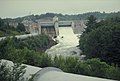 Dam, with water flowing after a hurricane had caused record high water. The flume (large pipe) transports water to generator, miles away.