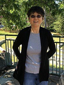 Wang is standing and smiling in an outdoor setting.